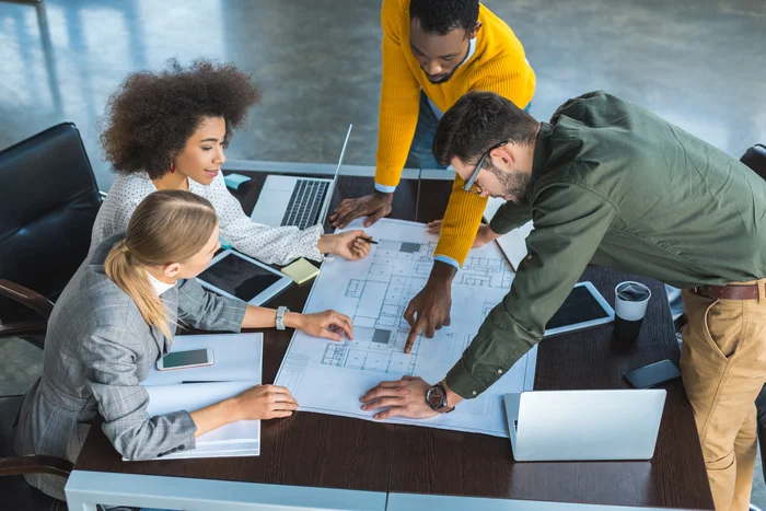 A team collaborates around a table with digital equipment.