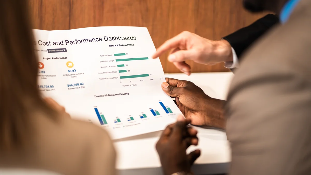 A presenter holds a report showing a chart.