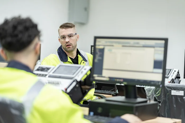 Two security professionals sit in an office discussion.