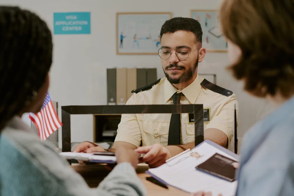 An officer conducts a welfare interview across a counter.