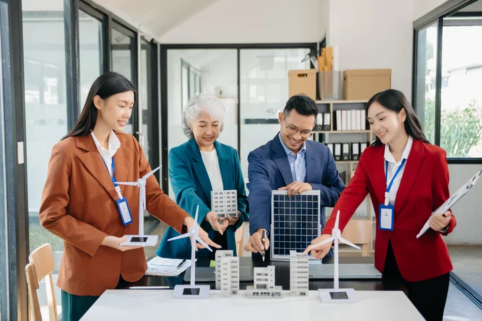 Several professionals review a tablet together in an office.