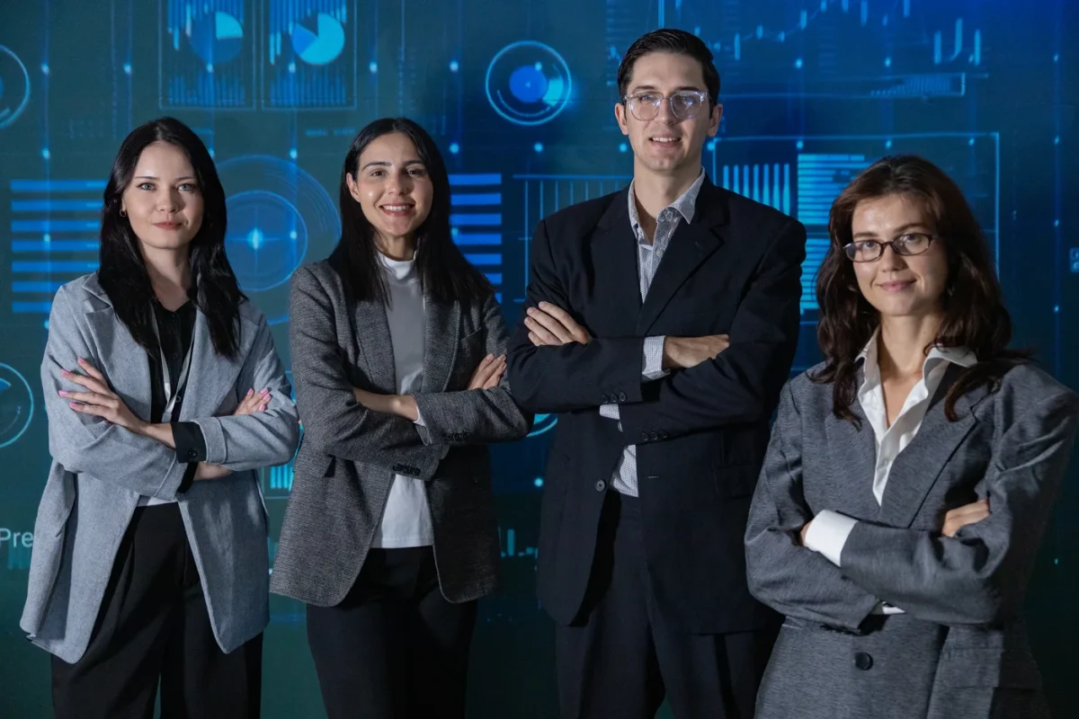 A professional team stands before a large blue digital operations interface