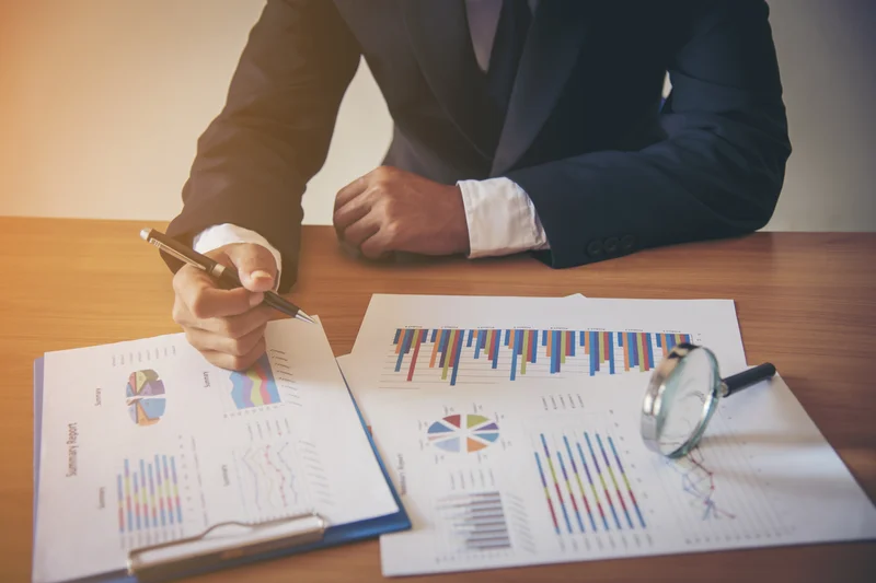 A hand writes a business research diagram on a whiteboard.