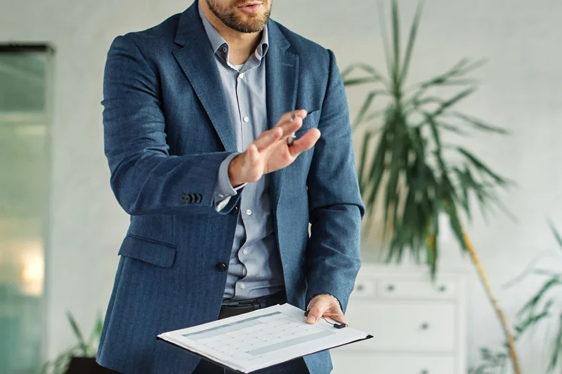 A presenter speaks to seated colleagues in an office