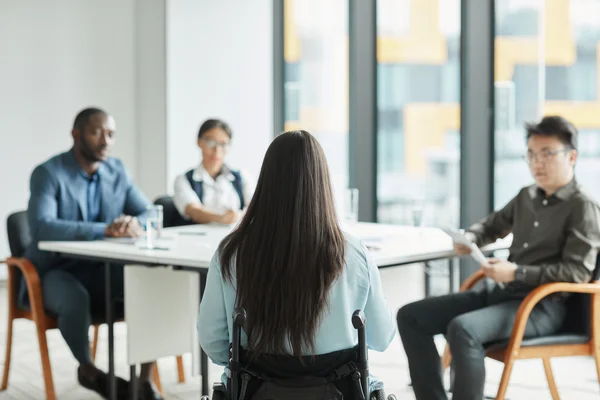 A presenter speaks to a small group beneath an employee-engagement slide.